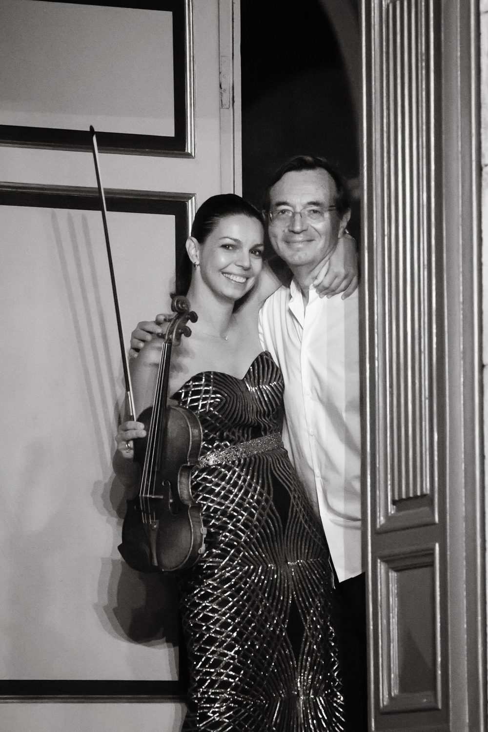 Igor Raykhelson with Ekaterina Astashova, who holds her violin, in a doorway
